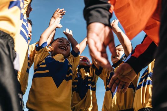 Indigenous Children with Hands Up in a Sporting Event